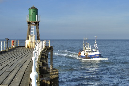 Fishing boat passing Whitby Pier.