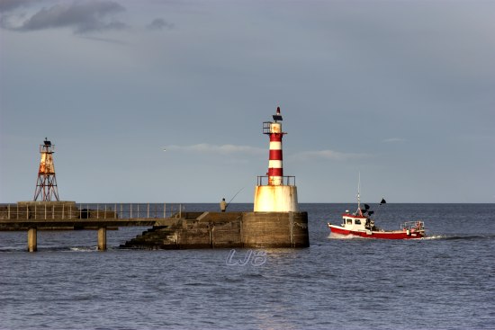 Fishing boat passing Amble Lighthouse on it's way to Amble Harbour.