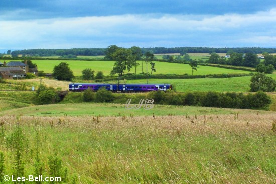 Passenger train on the Settle to Carlisle Railway beside the River Eden.