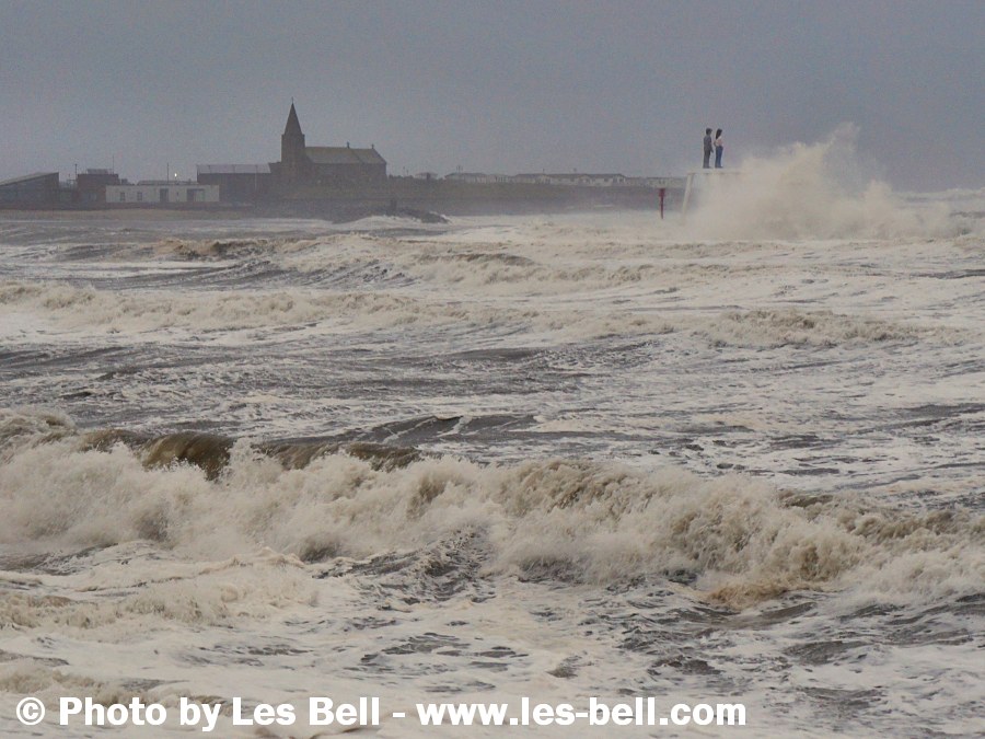 Stormy sea engulfing the couple sculpture at Newbiggin on the Northumberland Coast.